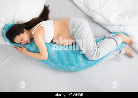 High angle view of pregnant woman sleeping on bed Banque D'Images