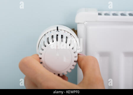Close-up of woman's hand réglage soupape thermostatique du radiateur à la maison Banque D'Images
