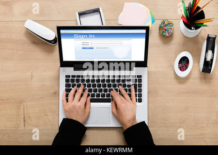 Vue en grand angle d'Une femme d'affaires se connectant au site Web sur un ordinateur portable Banque D'Images