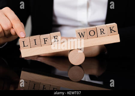 Close-up d'une personne montrant Déséquilibre entre vie et travail sur Seesaw Banque D'Images