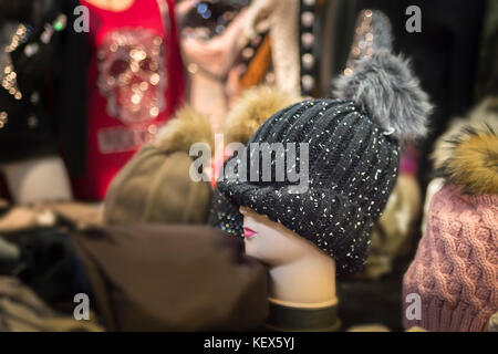 Bonnet en laine avec pom pom sur la perruque se tiennent sur un stand de marché Banque D'Images
