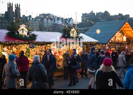 ÉDIMBOURG, ÉCOSSE, Royaume-Uni – 08 décembre 2014 - les gens marchent parmi les étals du marché de noël allemand à Édimbourg, Écosse, Royaume-Uni, avec le château d'Édimbourg Banque D'Images