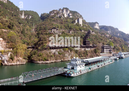 Un important quai flottant pour les passagers de croisière s'étend sur l'avant d'un village aquatique traditionnel recréé sur le fleuve Yangtze, une excursion en bord de mer pour les touristes qui naviguent sur le fleuve entre Jingzhou et Chongqing. Les visiteurs grimpent sur l'escalier couvert jusqu'au village, une randonnée difficile. Banque D'Images