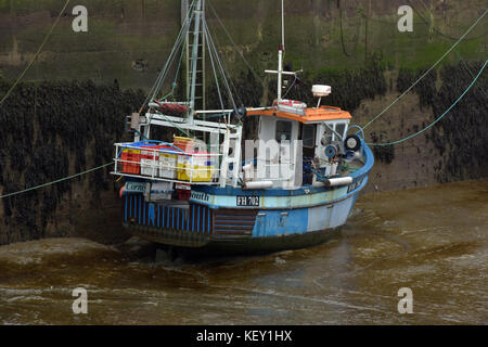 Un petit chalutier ou bateau de pêche le long du mur à Padstow Harbour en Cornouailles du nord le déchargement du poisson ou à l'abri dans le refuge d'une tempête. Banque D'Images