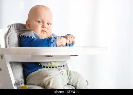 Baby eating bread et concombre avec méthode, BLW led bébé sevrage, looking at camera. Heureux végétariens kid au dîner. Tout-petit manger lui-même, auto-alimentation Banque D'Images