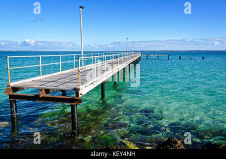 Jetée en bois endommagés désaffecté sur fond de sable à l'eau claire et ciel bleu, rockingham Australie occidentale Banque D'Images