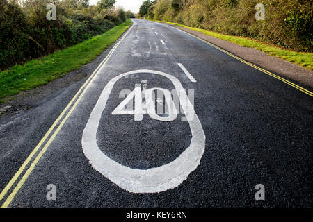 La limite de vitesse de 40 mi/h inscription peinte sur une route dans la campagne Banque D'Images