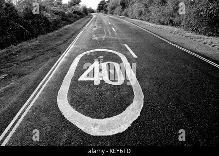 La limite de vitesse de 40 mi/h inscription peinte sur une route dans la campagne Banque D'Images