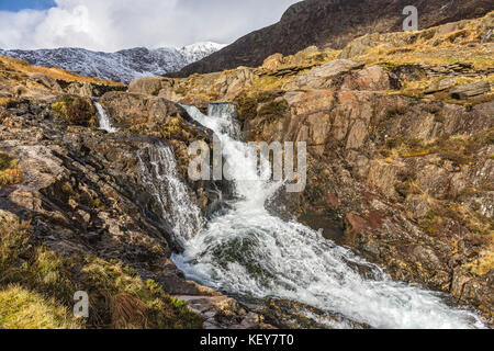 Chute d'Afon (rivière) mcg Llançà près du chemin d'Watkin Mont Snowdon avec la crête couverte de neige au sommet dans l'arrière-plan le Snowdonia Banque D'Images