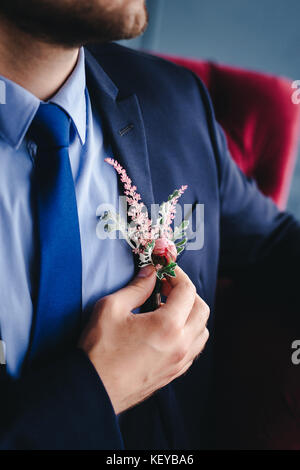 Matin, marié Marié dans une veste, le marié se redresse la boutonnière, jour de mariage Banque D'Images