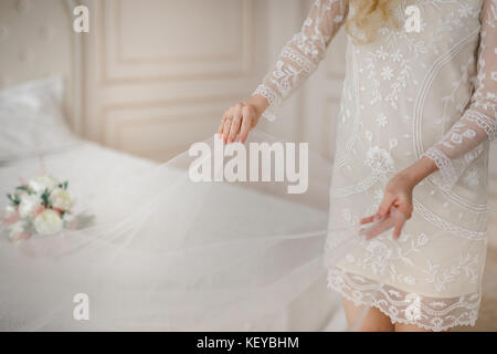 Mariée de demoiselle d'honneur de la préparation pour le jour du mariage, aider fixer sa robe. Détails de mariage Banque D'Images