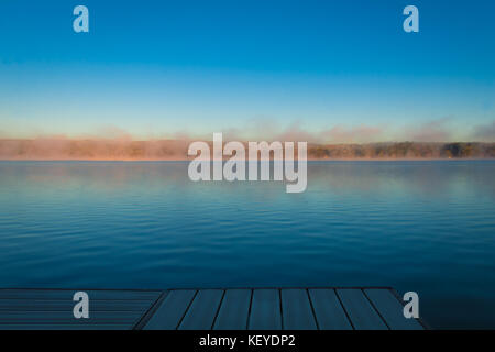 Un dock surplombe un lac calme comme le brouillard se lèvera le matin au début de l'automne à silver lake, Castille, ny Banque D'Images