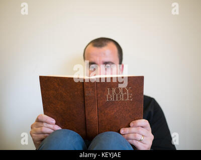 Man reading bible sur fond blanc Banque D'Images