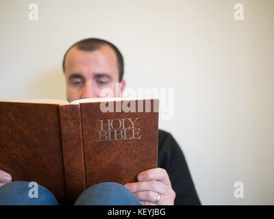 Man reading bible sur fond blanc Banque D'Images