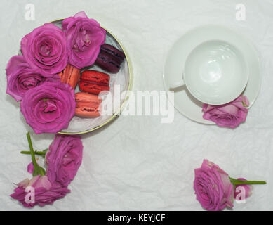 Télévision à jeter d'une tasse de thé, macarons et roses roses dans une boîte-cadeau Banque D'Images