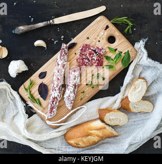 Snack-gastronomique de la viande, l'ail salami., baguette et herbes sur planche de bois rustique Banque D'Images