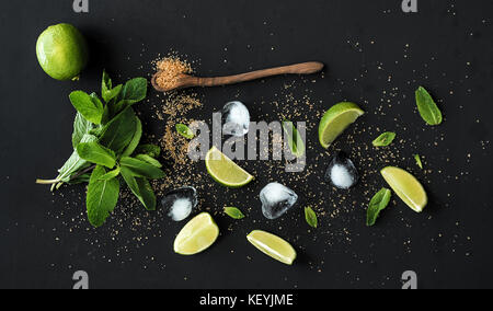 Ingrédients pour mojito. menthe fraîche, citron vert, sucre glace, sur fond noir Banque D'Images