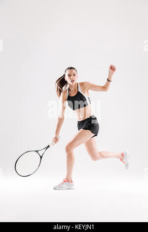 Toute la longueur d'un joueur de tennis avec une raquette prêt à frapper une balle isolated over white background Banque D'Images