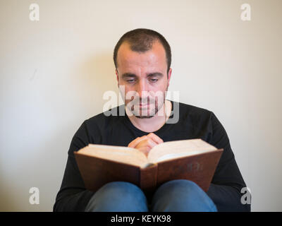 Man reading bible sur fond blanc Banque D'Images