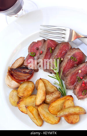 Tranches de steak de boeuf et frites sur une assiette Banque D'Images