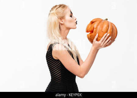 Portrait of a cute blonde woman in halloween citrouille incurvé de baisers isolated over white background Banque D'Images