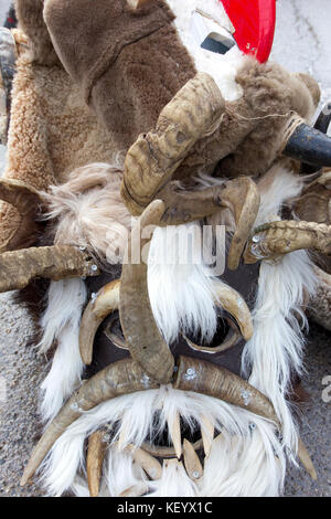 Un des masques d'acteurs traditionnels 'kukeri' sont allongés sur le sol pendant les jeux coutumiers en Bulgarie. Banque D'Images