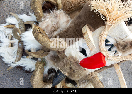 Un des masques d'acteurs traditionnels 'kukeri' sont allongés sur le sol pendant les jeux coutumiers en Bulgarie. Banque D'Images