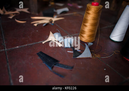 Des bobines de fils et de morceaux de textile sont visibles sur le plancher d'un petit atelier de fabrication de chaussures à San Salvador, El Salvador, 16 novembre 2016. Banque D'Images