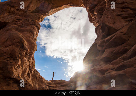 En femme debout dans la tourelle du rétroéclairage arch dans le Arches national park, Utah, USA Banque D'Images