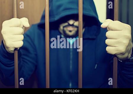 Abstract. Les mains du prisonnier sur un treillis en acier de près. L'homme en prison, menottes. Banque D'Images