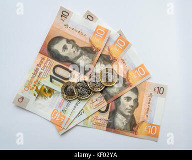 Polymère plastique Clydesdale Bank Scottish 10 livres £10 billets avec Robert Burns et hexagonaux une livre €1 pièces sur un arrière-plan uni, blanc Banque D'Images