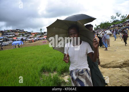 Réfugiés rohingyas marcher à travers un champ de riz à l'palongkhali camp de fortune à Cox's bazar, Bangladesh, le 06 octobre, 2017. selon l'uni Banque D'Images