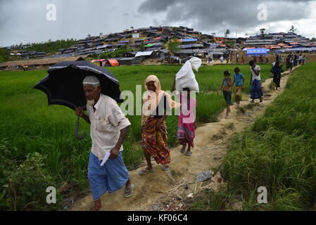 Réfugiés rohingyas marcher à travers un champ de riz à l'palongkhali camp de fortune à Cox's bazar, Bangladesh, le 06 octobre, 2017. selon l'uni Banque D'Images