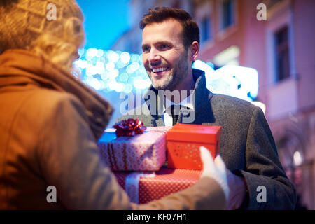 Homme mûr de recevoir plein de cadeaux de femme Banque D'Images