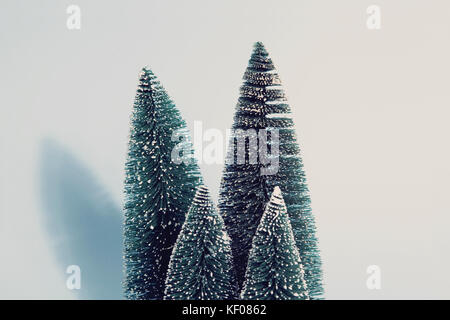 Photographie vintage de filtré groupe isolé de sapins artificiels complet comme une petite forêt d'arbre sur un fond bleu pastel. minimal still life photographe Banque D'Images