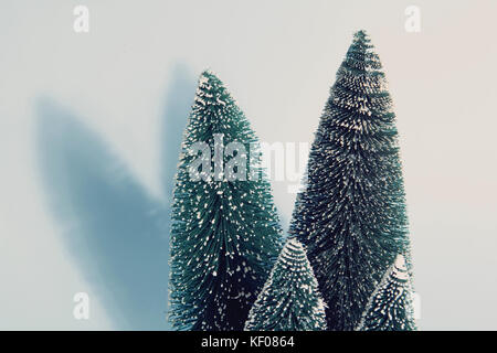 Photographie vintage de filtré groupe isolé de sapins artificiels complet comme une petite forêt d'arbre sur un fond bleu pastel. minimal still life photographe Banque D'Images