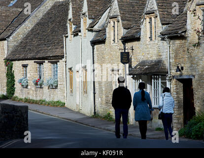 Trois touristes asiatiques explorer le village de Castle Combe, Wiltshire, Angleterre, Royaume-Uni Banque D'Images