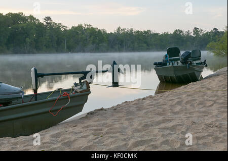 Deux bateaux de pêche amarrés sur sable sur les rives de la rivière Altamaha en Géorgie au coucher du soleil. Banque D'Images