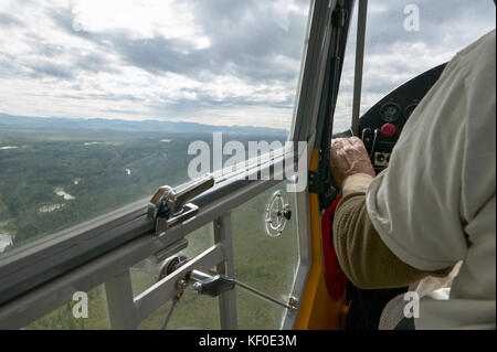 Vue intérieure d'un petit avion de brousse avec un pilote et une grande fenêtre avec vue paysage de la nature en Alaska Banque D'Images