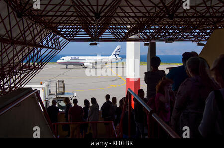 Un Airbus A320 de la compagnie Aegean Airways débarquant à l'aéroport d'Héraklion, en Crète, en Grèce, sous la surveillance de passagers. Banque D'Images