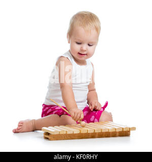 Petite fille avec l'excitation de jouer sur le xylophone isolé sur blanc. Banque D'Images