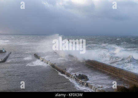 Port de Burghead en Écosse d'être battues par les énormes vagues s'écraser sur la mer défenses sur pendant une tempête. Banque D'Images