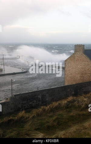 Port de Burghead en Écosse d'être battues par les énormes vagues s'écraser sur la mer défenses sur pendant une tempête. Banque D'Images