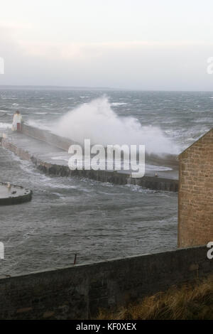 Port de Burghead en Écosse d'être battues par les énormes vagues s'écraser sur la mer défenses sur pendant une tempête. Banque D'Images