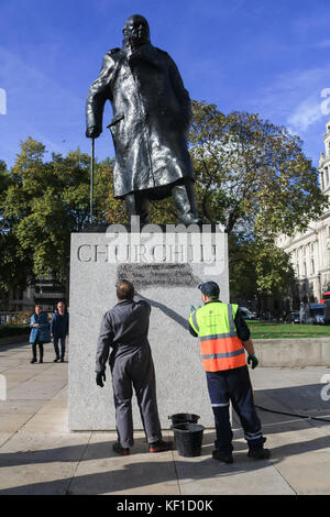 Londres, Royaume-Uni. 25 octobre, 2017 Conseil de Westminster. unité anti graffiti laver et nettoyer les graffiti à l'écrit encore lisible ''la prison et les camps nazis sont la même chose" sur la statue de sir Winston Churchill en face du palais de Westminster laissés par les manifestants de la jungle de calais le jour précédent. crédit : amer ghazzal/Alamy live news Banque D'Images