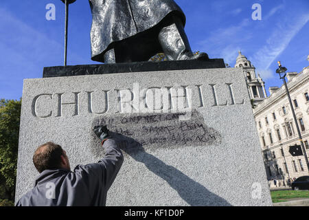 Londres, Royaume-Uni. 25 octobre, 2017 Conseil de Westminster. unité anti graffiti laver et nettoyer les graffiti à l'écrit encore lisible ''la prison et les camps nazis sont la même chose" sur la statue de sir Winston Churchill en face du palais de Westminster laissés par les manifestants de la jungle de calais le jour précédent. crédit : amer ghazzal/Alamy live news Banque D'Images