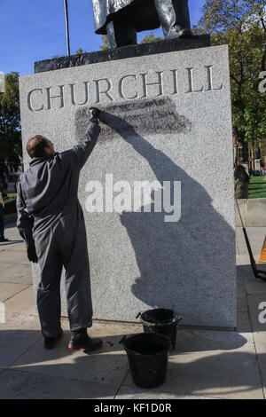 Londres, Royaume-Uni. 25 octobre, 2017 Conseil de Westminster. unité anti graffiti laver et nettoyer les graffiti à l'écrit encore lisible ''la prison et les camps nazis sont la même chose" sur la statue de sir Winston Churchill en face du palais de Westminster laissés par les manifestants de la jungle de calais le jour précédent. crédit : amer ghazzal/Alamy live news Banque D'Images