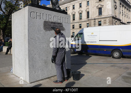 Londres, Royaume-Uni. 25 octobre, 2017 Conseil de Westminster. unité anti graffiti laver et nettoyer les graffiti à l'écrit encore lisible ''la prison et les camps nazis sont la même chose" sur la statue de sir Winston Churchill en face du palais de Westminster laissés par les manifestants de la jungle de calais le jour précédent. crédit : amer ghazzal/Alamy live news Banque D'Images