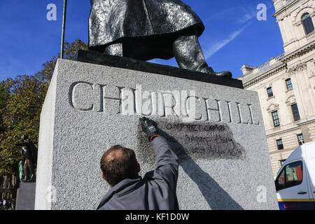 Londres, Royaume-Uni. 25 octobre, 2017 Conseil de Westminster. unité anti graffiti laver et nettoyer les graffiti à l'écrit encore lisible ''la prison et les camps nazis sont la même chose" sur la statue de sir Winston Churchill en face du palais de Westminster laissés par les manifestants de la jungle de calais le jour précédent. crédit : amer ghazzal/Alamy live news Banque D'Images