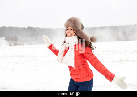 Happy woman in winter fur hat s'amuser en plein air Banque D'Images